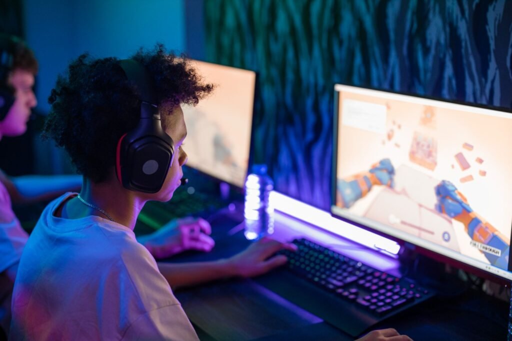 A young boy in black headphones playing a game at a computer, illustrating a child running YouTube ad campaigns