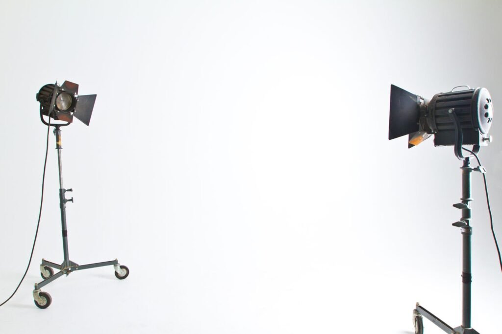 Two studio lights standing in an empty production studio, illustrating an AI-generated sitcom made without a crew