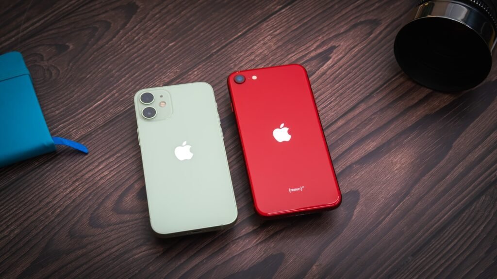 Two older iPhone models resting on a wooden table, illustrating iPhone trade-in values before a new launch