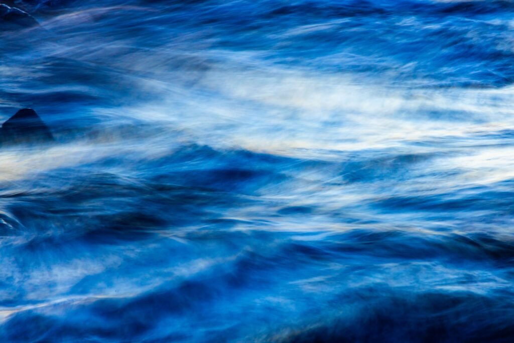 OpenAI Says Its Next Model Solved a $1 Million Math Problem. A Rival Lab’s Researchers Say They Got There First. Abstract blue turbulent fluid waves representing the Navier-Stokes equations