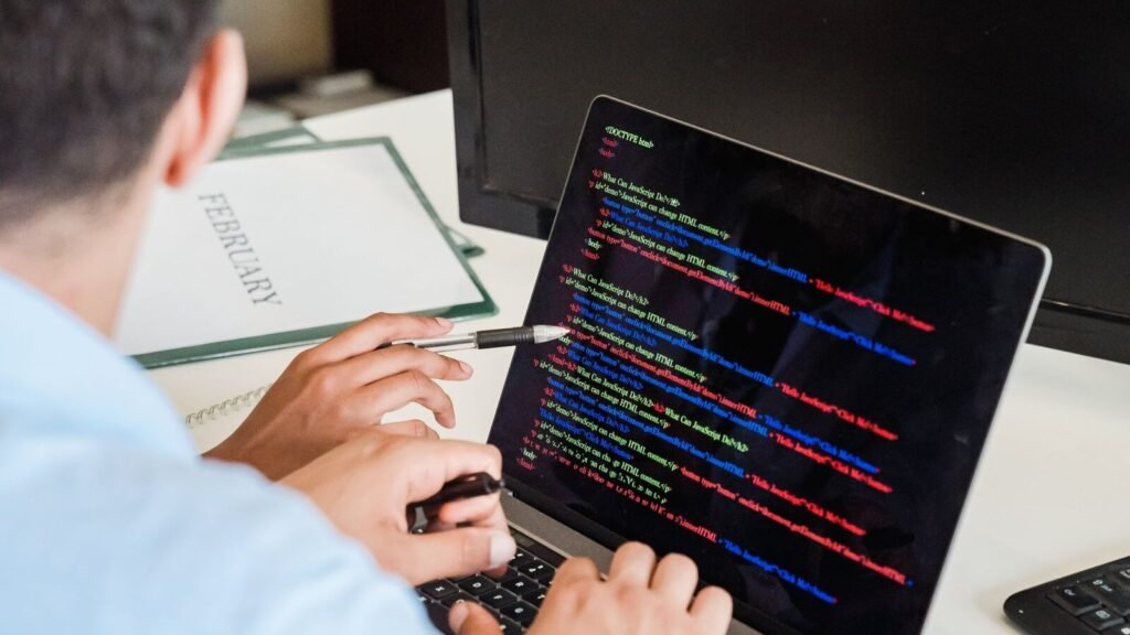 Person typing code on a laptop in an office