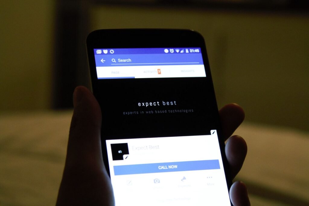 A hand holding a small smartphone, illustrating the compact Enough Phone with its removable battery