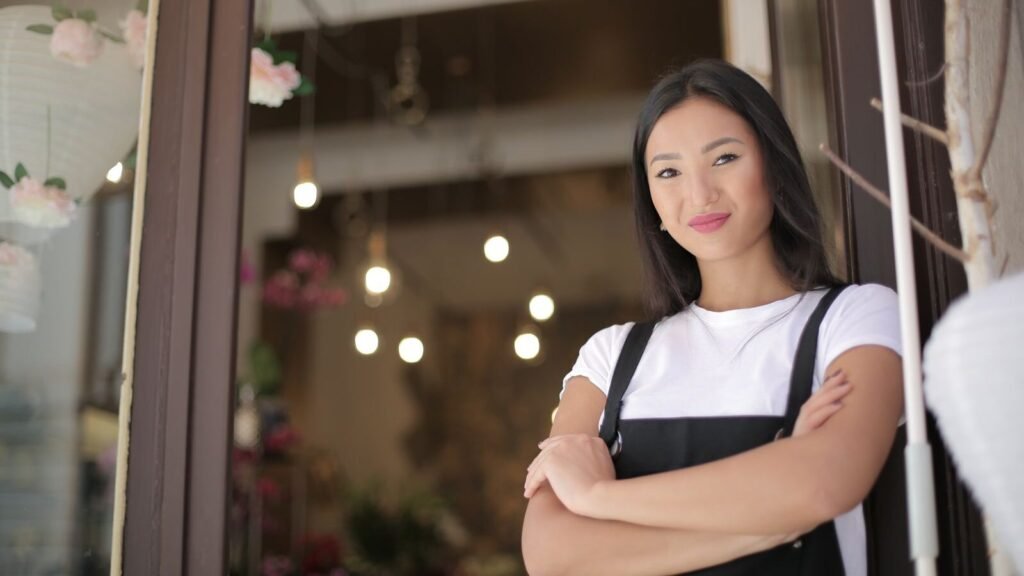 Best State to Start an LLC: Washington or Oregon? Florist standing at the entrance of her shop