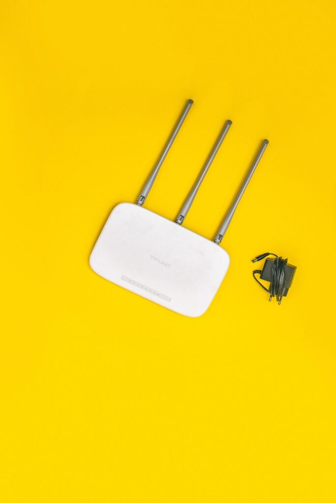 Your Boss Can See Which Sites You Visit on Work Wi-Fi. One Setting Decides Whether They See More. A wireless router on a plain yellow background, representing an office Wi-Fi network