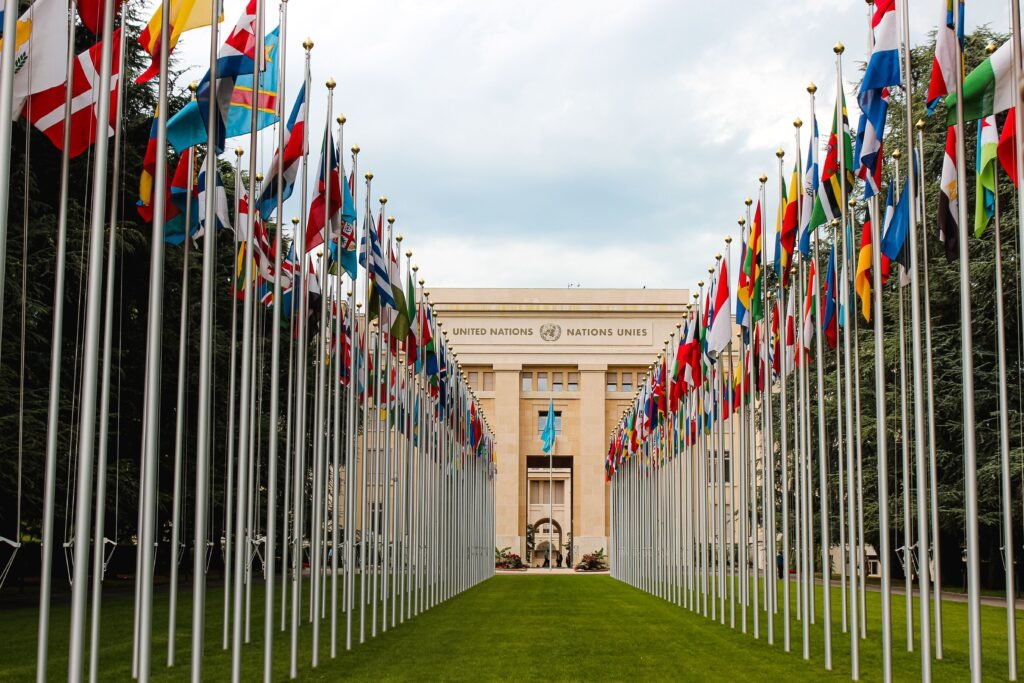 Flags of United Nations member countries flying outside a UN office, illustrating international AI governance talks