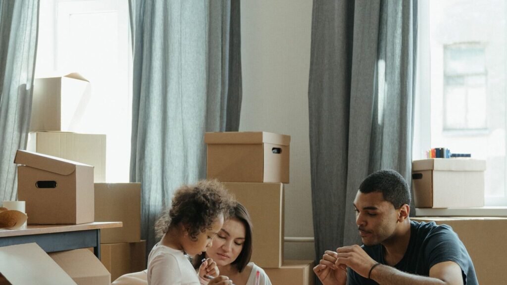 Family organizing cardboard boxes while moving