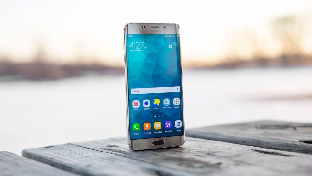 Samsung smartphone on a wooden surface at sunset