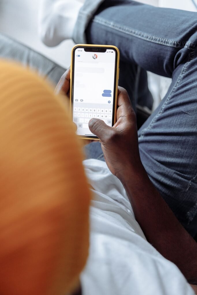 Google Messages Copied iMessage Backgrounds. It Fixed the Part Apple Got Wrong. A person texting on a smartphone, illustrating custom chat themes and backgrounds in Google Messages