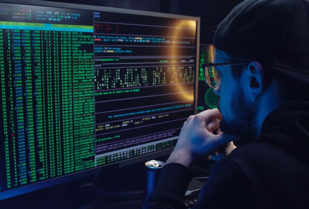 A person working on a laptop in a dark room, illustrating what ChatGPT can see on your computer through the __obi cookie and Computer History