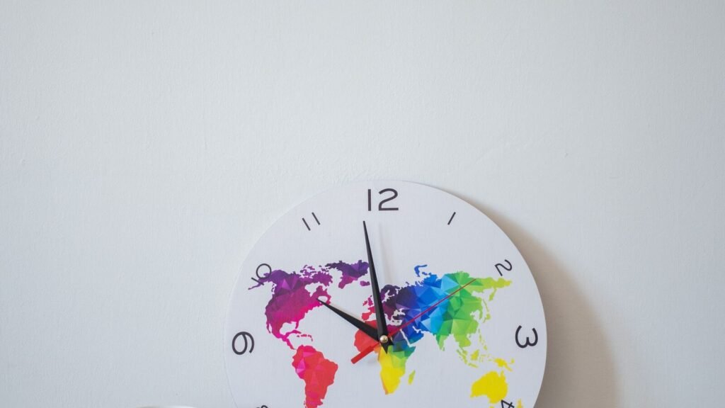 Round clock with a colorful world map face, illustrating converting GMT to other time zones in C++