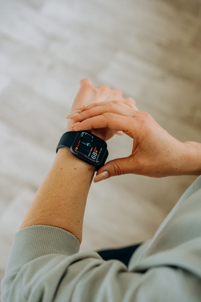 Best Smartwatch for Health Monitoring in 2026: What Each One Actually Tracks Woman looking at health and heart rate data on her black smartwatch indoors