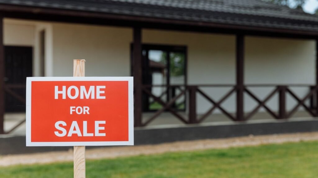 House with a for sale sign on the front lawn