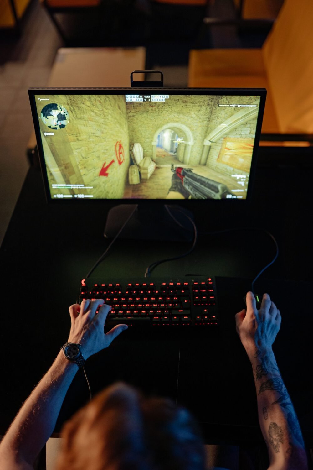 A gamer viewed from above, streaming a game on a laptop