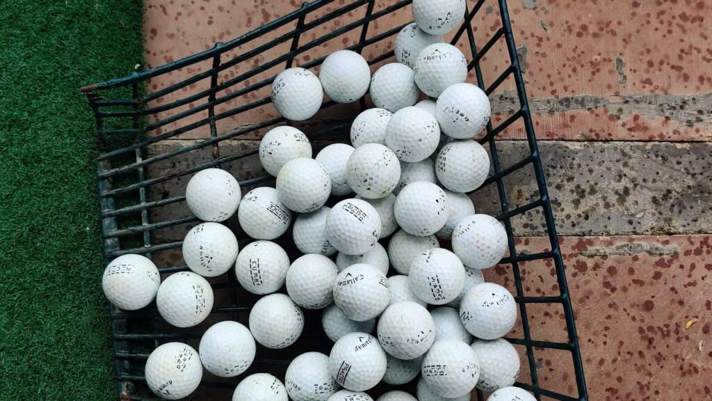 How to Store Golf Balls in the Off Season Basket of golf balls next to green turf