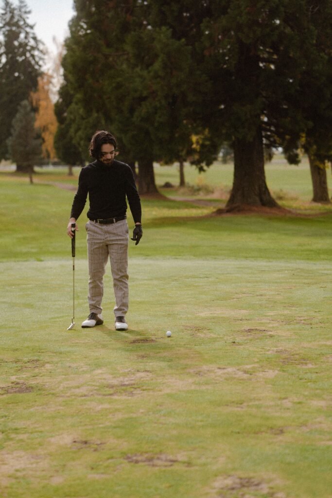 Golfer swinging a club on a fairway, an example of the setting where a golf GPS smartwatch is used