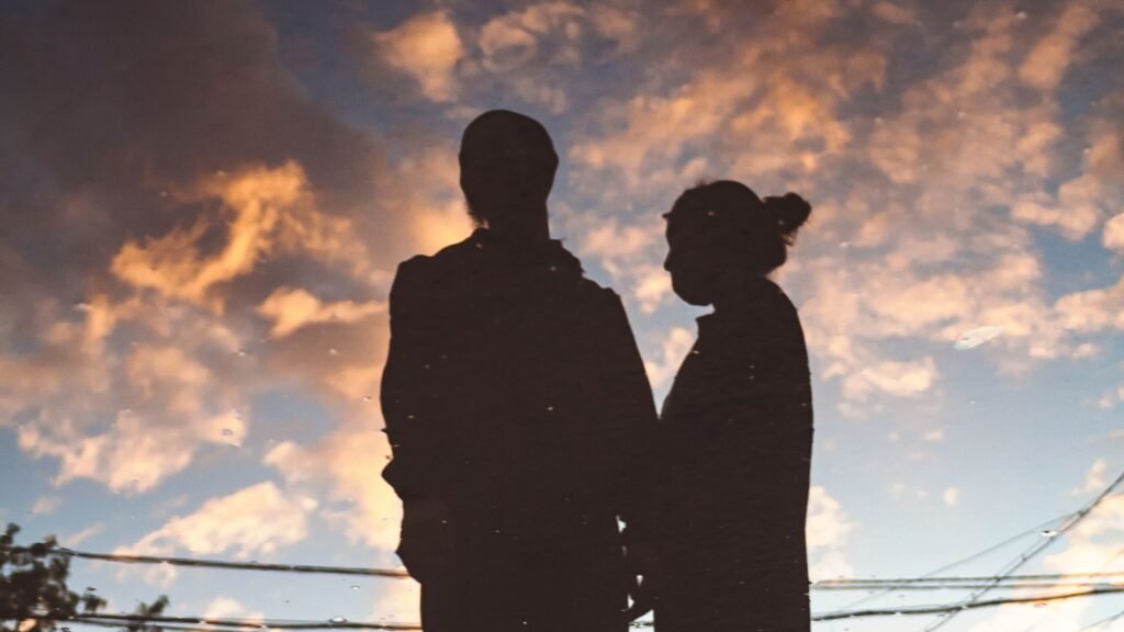 Silhouette of a couple holding hands, their faces not visible