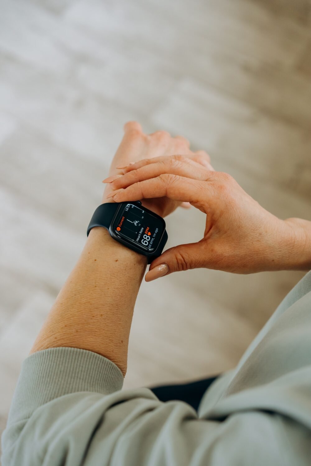Person checking a black smartwatch on their wrist indoors