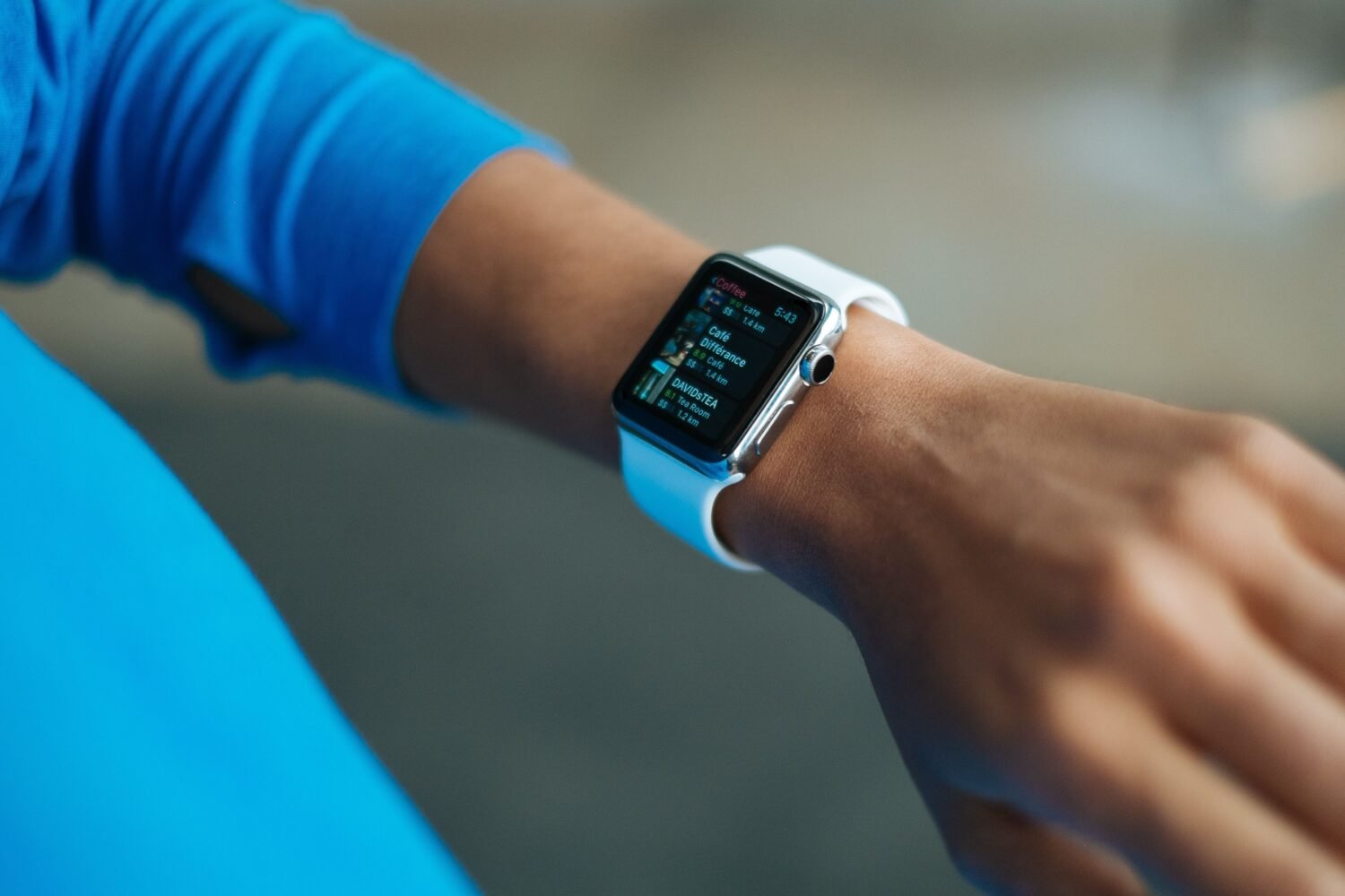 Close-up of a black smartwatch with a silicone strap on a wrist