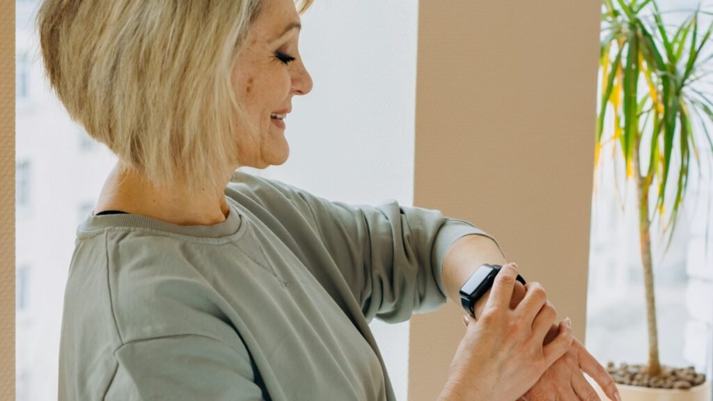 Elderly woman looking at the fall detection alert on her smartwatch indoors