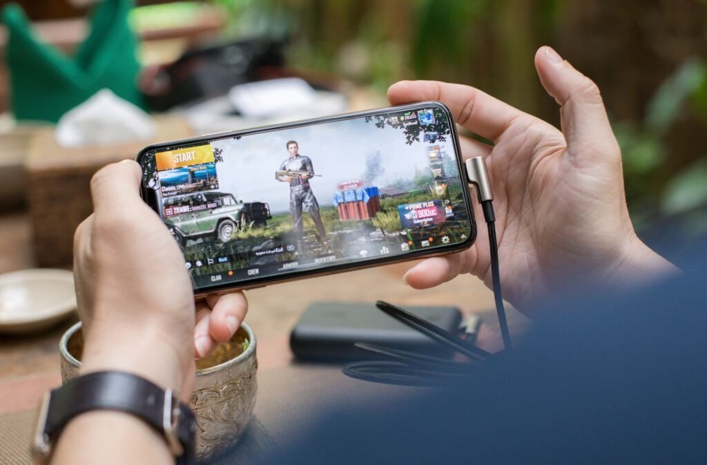 Hands holding a smartphone while playing a mobile game, illustrating the gaming focus of the Poco F9 Ultra