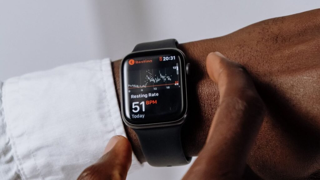 Person wearing a smartwatch with a white silicone sport band on their wrist
