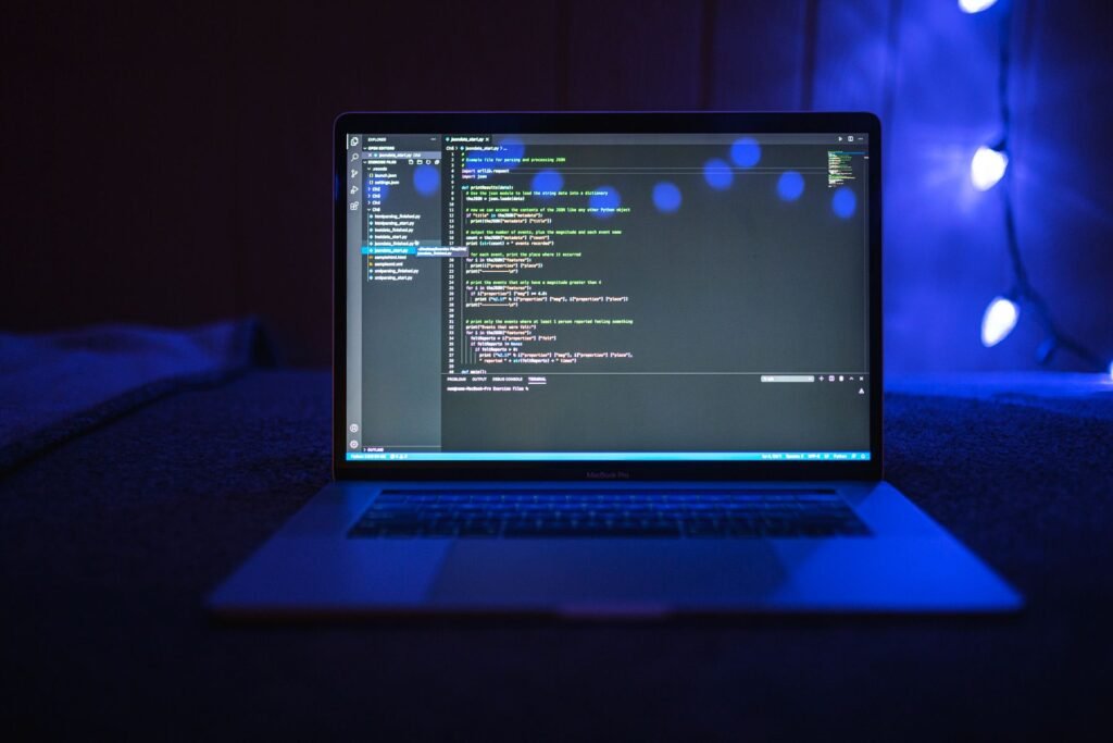 Close-up of code on a dark laptop screen with blue lighting, representing AI agent test environments