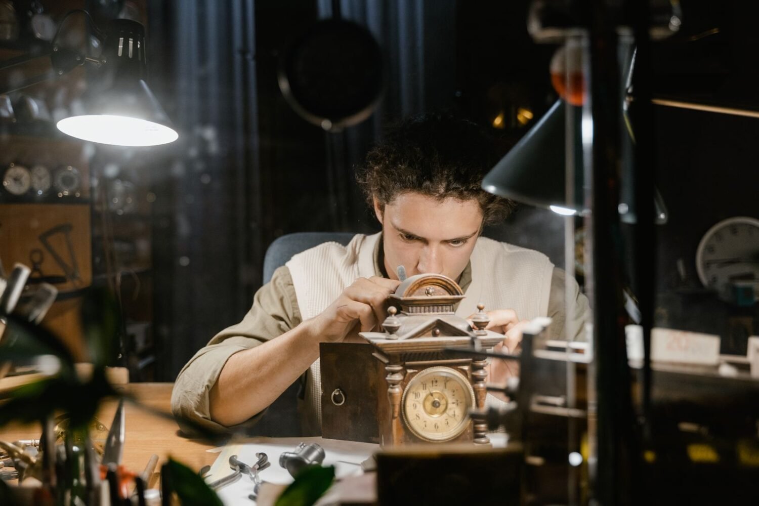 Watchmaker repairing a timepiece with precision tools at a workbench