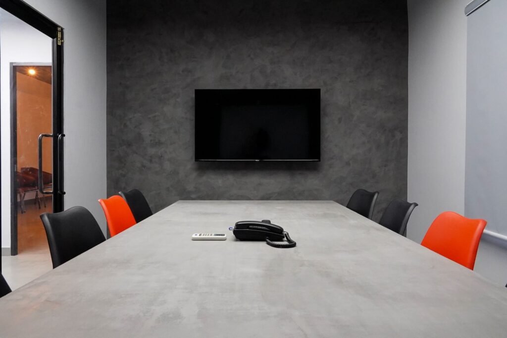 Executive conference room with a long table and a wall-mounted TV