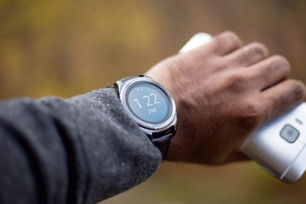 Silver smartwatch with a black strap on a person's wrist