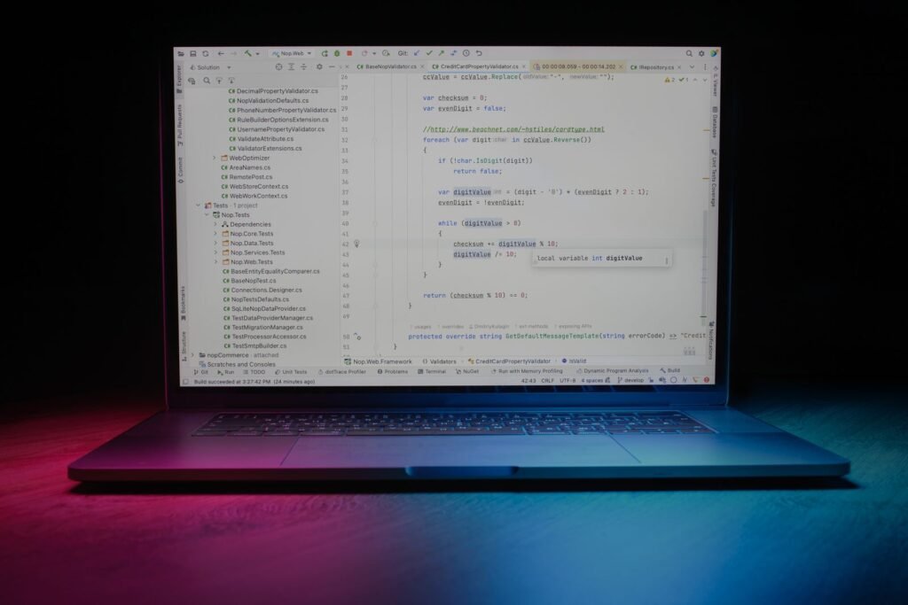 Laptop open on a desk showing code under neon lighting, illustrating vibe-coded private Android apps on Google Play