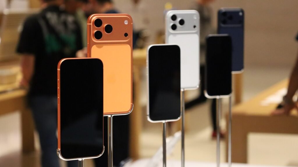 iPhone 17 Pro phones in Cosmic Orange, Silver and Deep Blue on display stands in an Apple Store