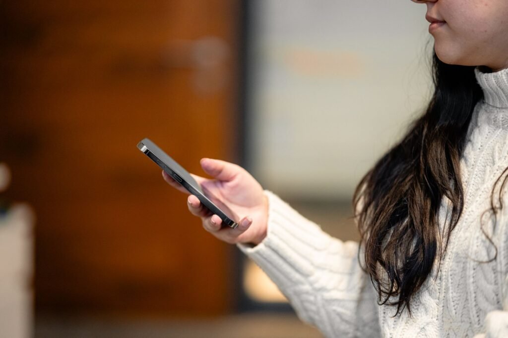 Close-up side view of a woman holding an iPhone, illustrating the iPhone 18 Pro vs iPhone Air comparison