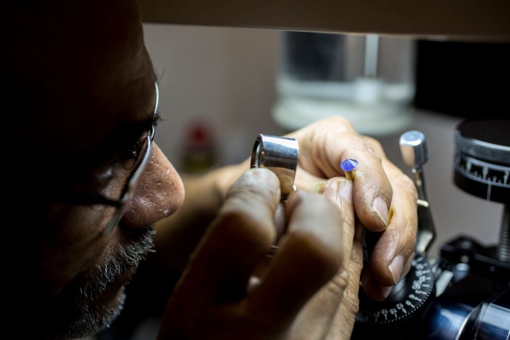 Jeweler inspecting a gemstone up close, illustrating the craftsmanship behind high jewelry