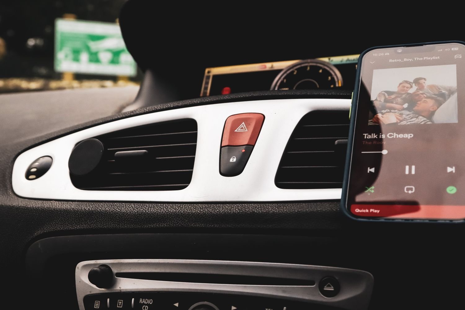 Smartphone in a car dashboard mount playing a song