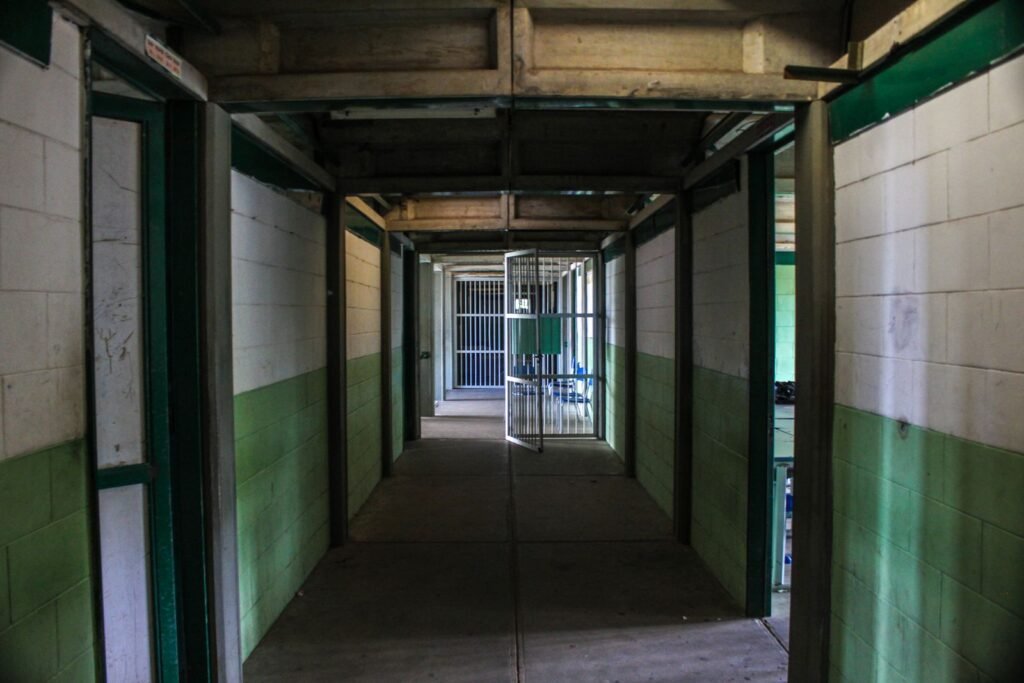 Empty prison corridor with open cell doors