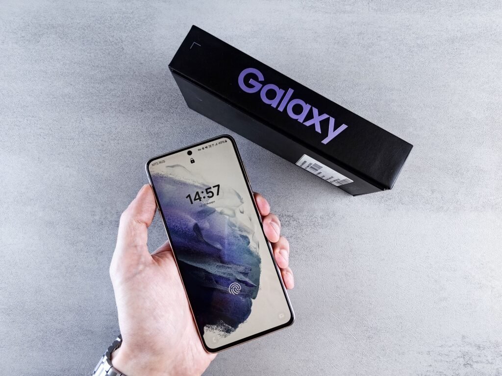 Samsung Raised Galaxy S26 Prices Seven Months In. The Phones Did Not Change. A hand holding a new Samsung Galaxy smartphone beside its retail box, the kind of purchase affected by the October 2026 Galaxy S26 price increase