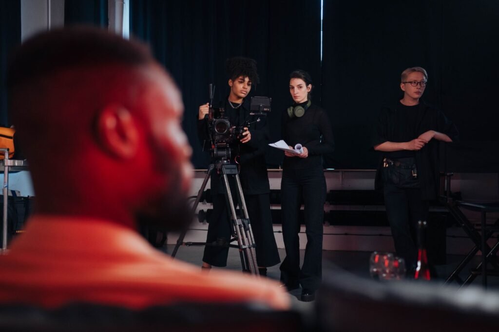 A film crew setting up cameras and lighting equipment in a studio, illustrating a hand made television production