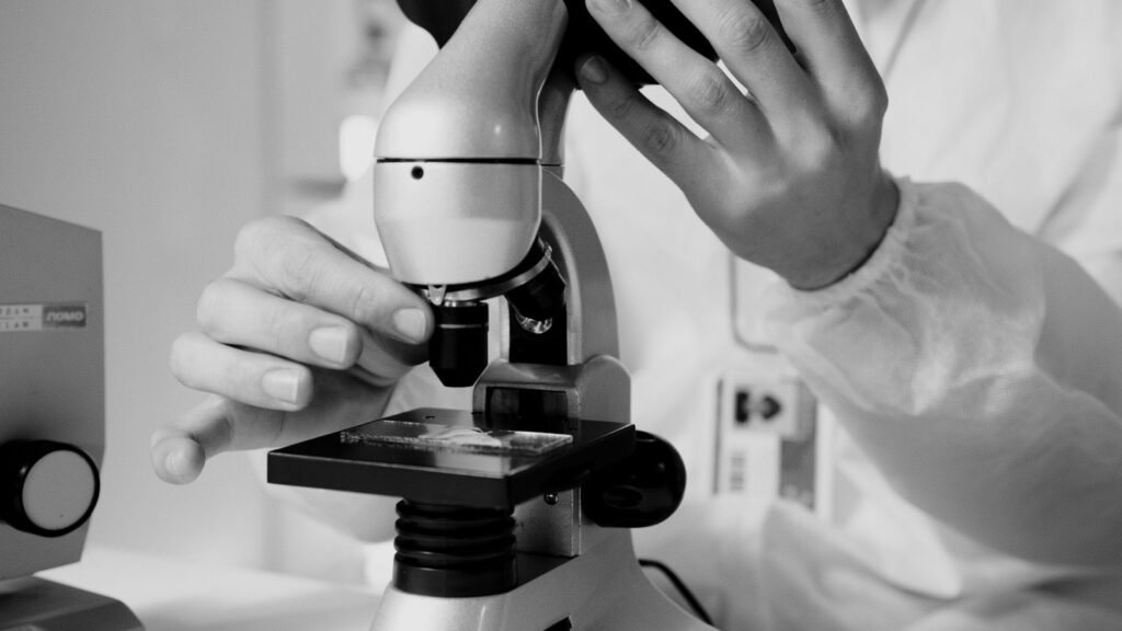 Researcher looking through a laboratory microscope
