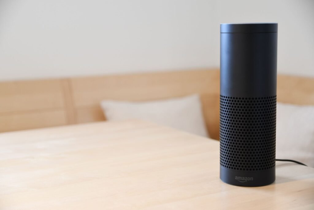 A black smart speaker sitting on a wooden table in a home, illustrating Apple's Welcome Home smart home event