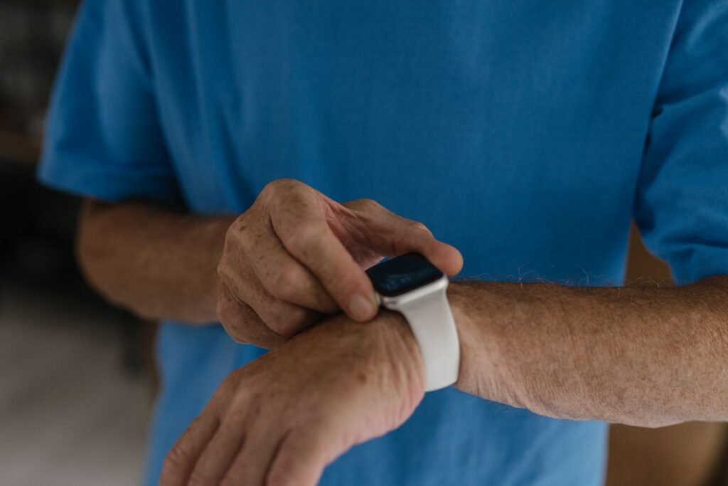 Person wearing a black and white smartwatch on the wrist, the kind of device used to track Parkinson's tremor