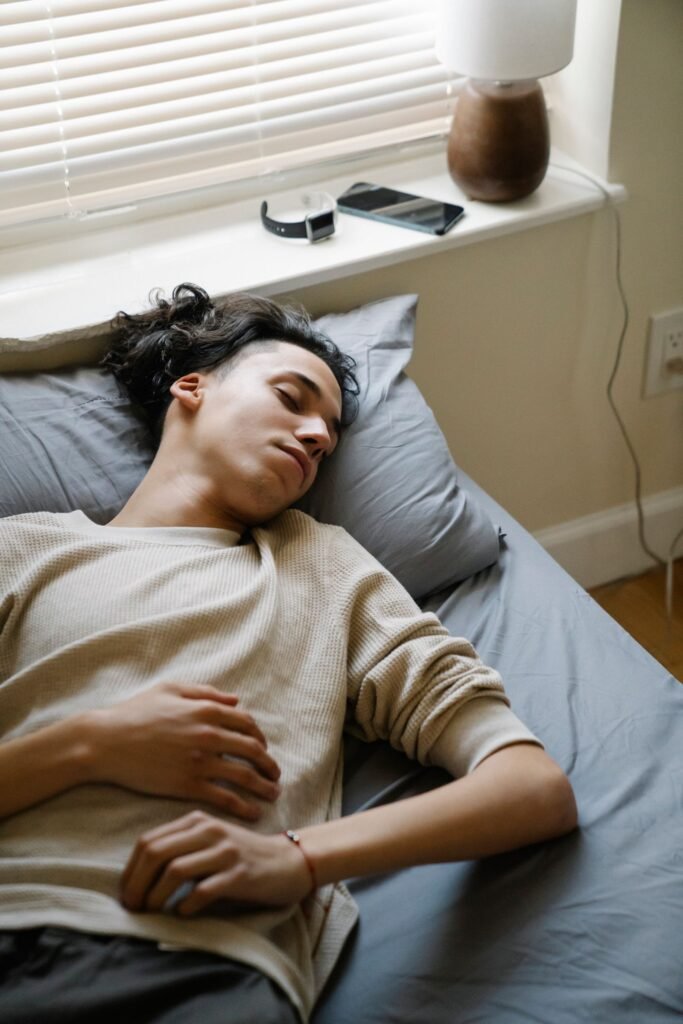 Man sleeping in bed in the morning with a smartwatch resting nearby