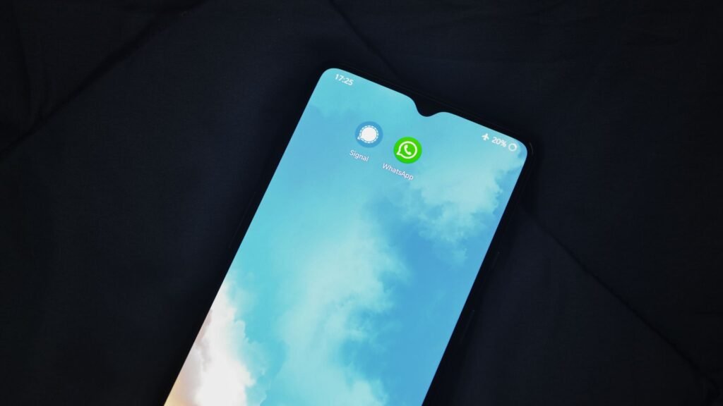 WhatsApp Pins Can Now Last Forever. Three More Group Chat Fixes Arrive With Them. Smartphone showing messaging app icons including WhatsApp